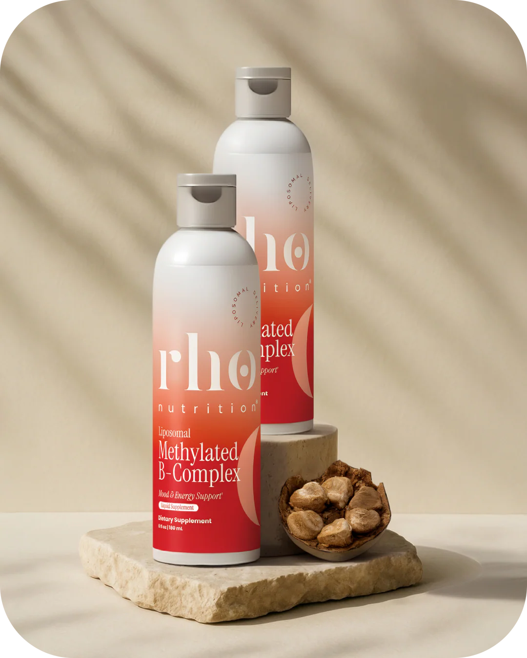 Two bottles of 'rho nutrition' on a stone surface with nuts on a beige background