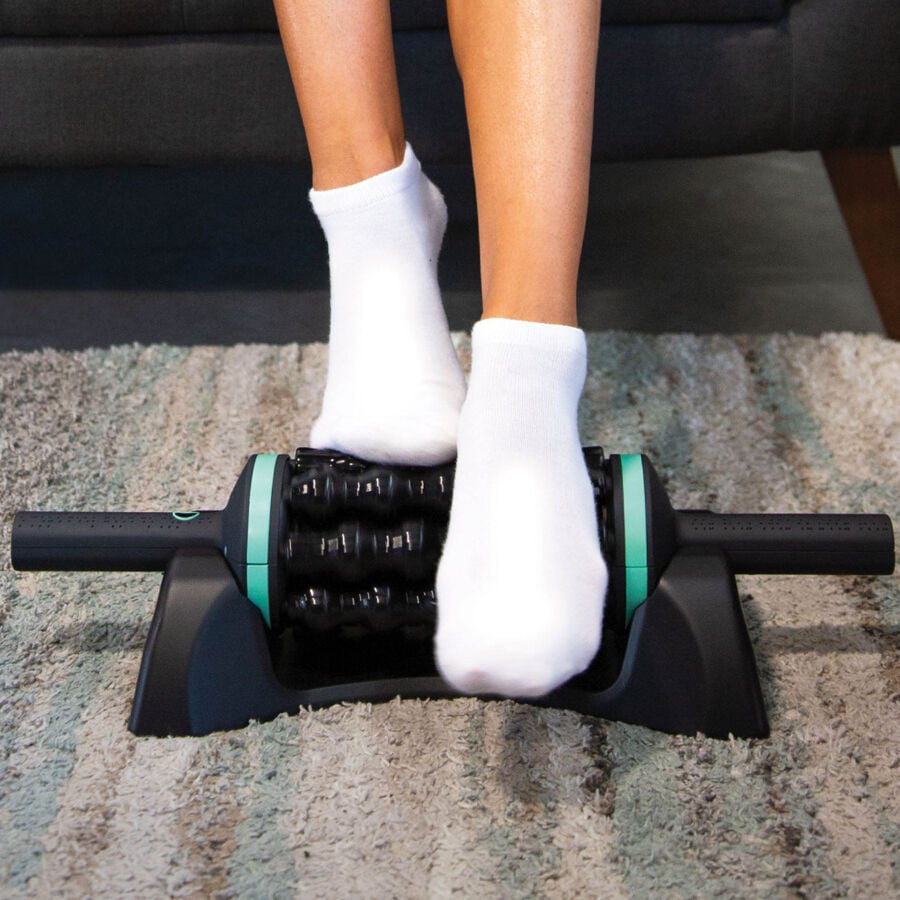 Person using Chirp RPM Rolling Powered Massager on a carpeted floor