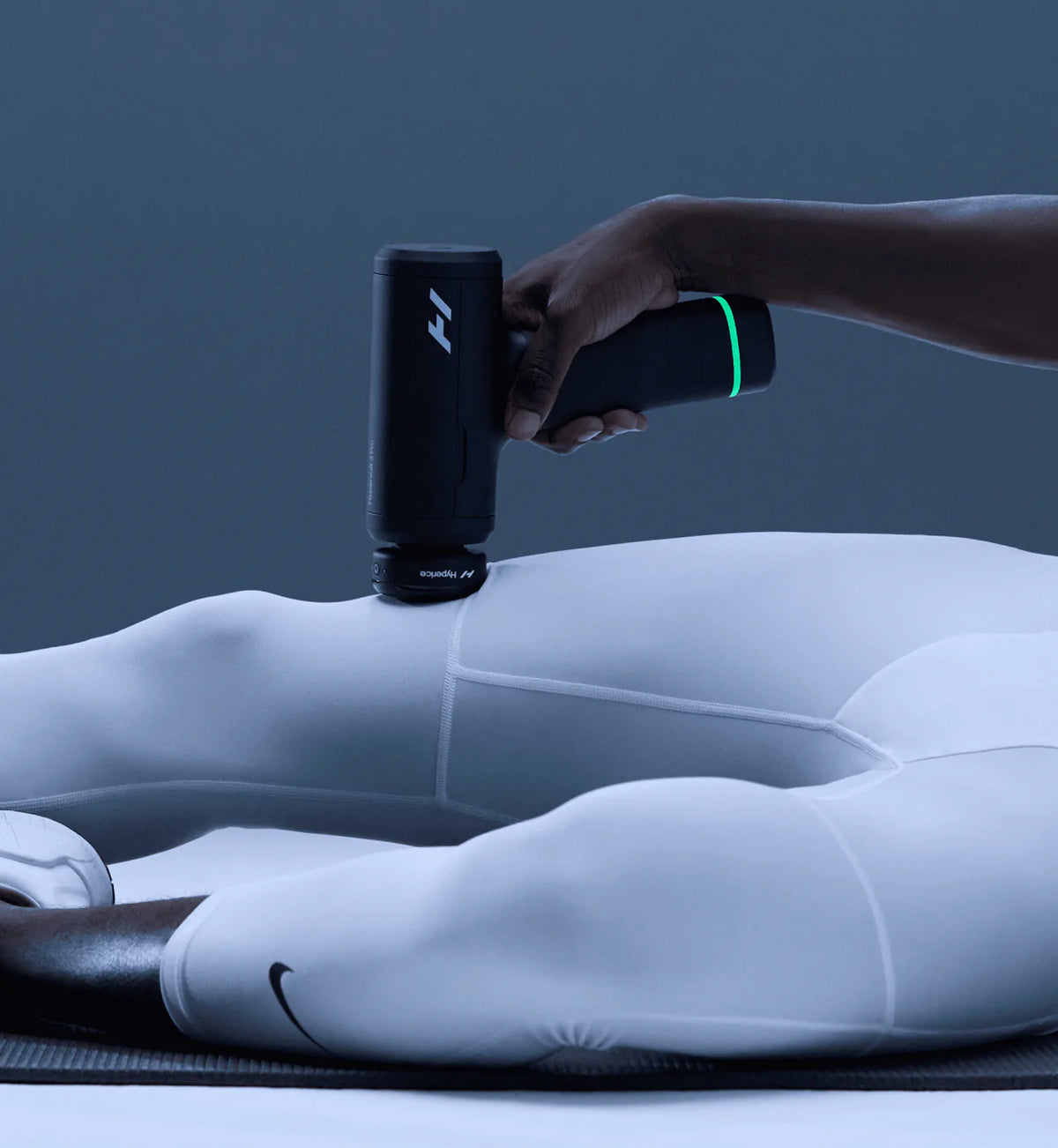 Person using Hyperice Heated Head Attachment on leg muscles