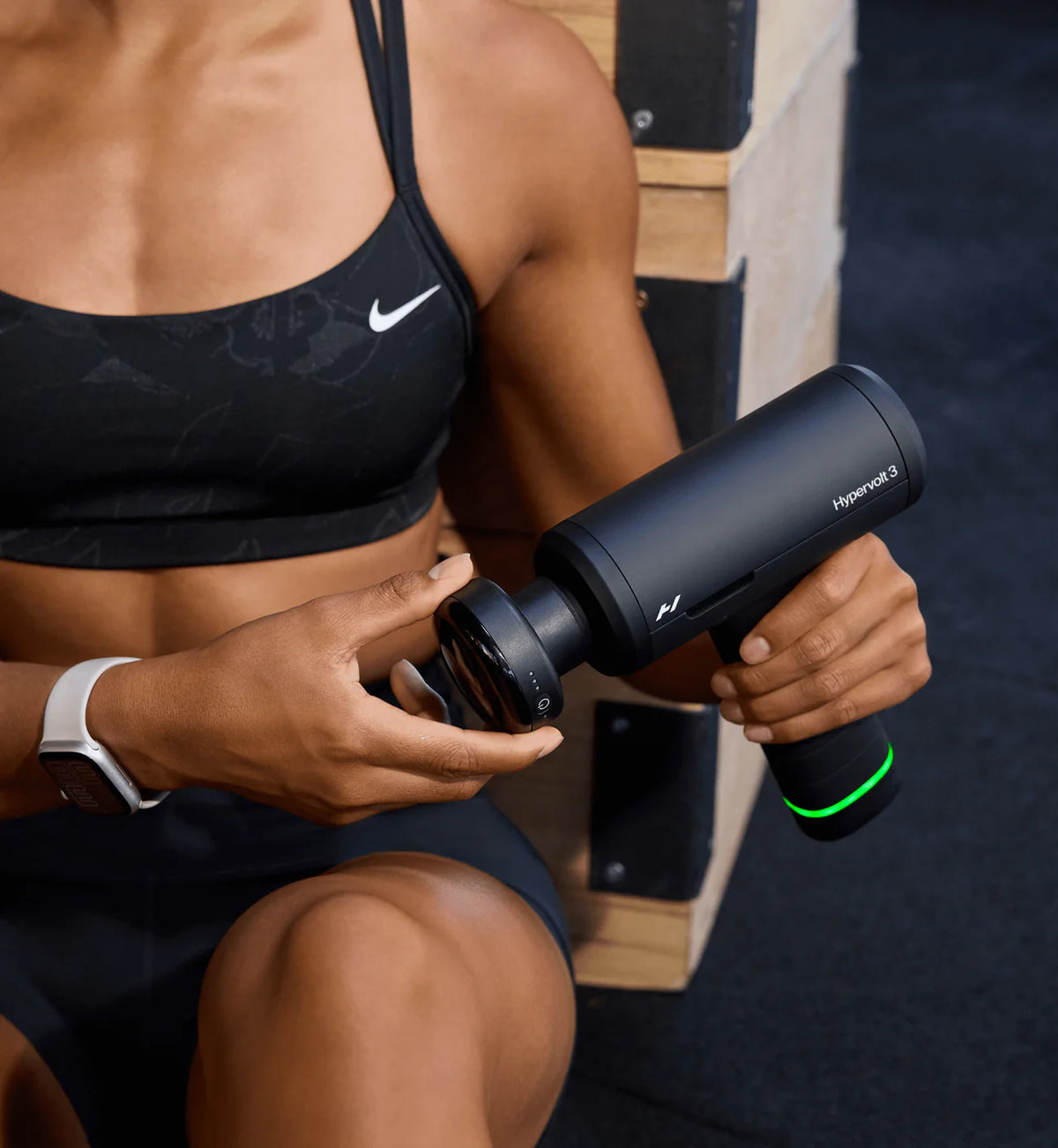Person using Hyperice Heated Head Attachment with a Hyperice massage device on the thigh