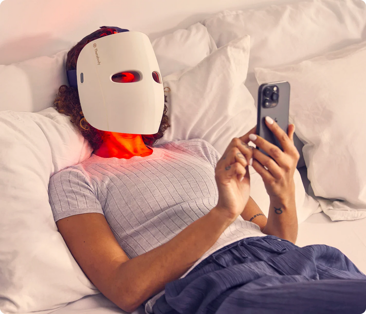 Women wearing Therabody TheraFace LED Mask while relaxing