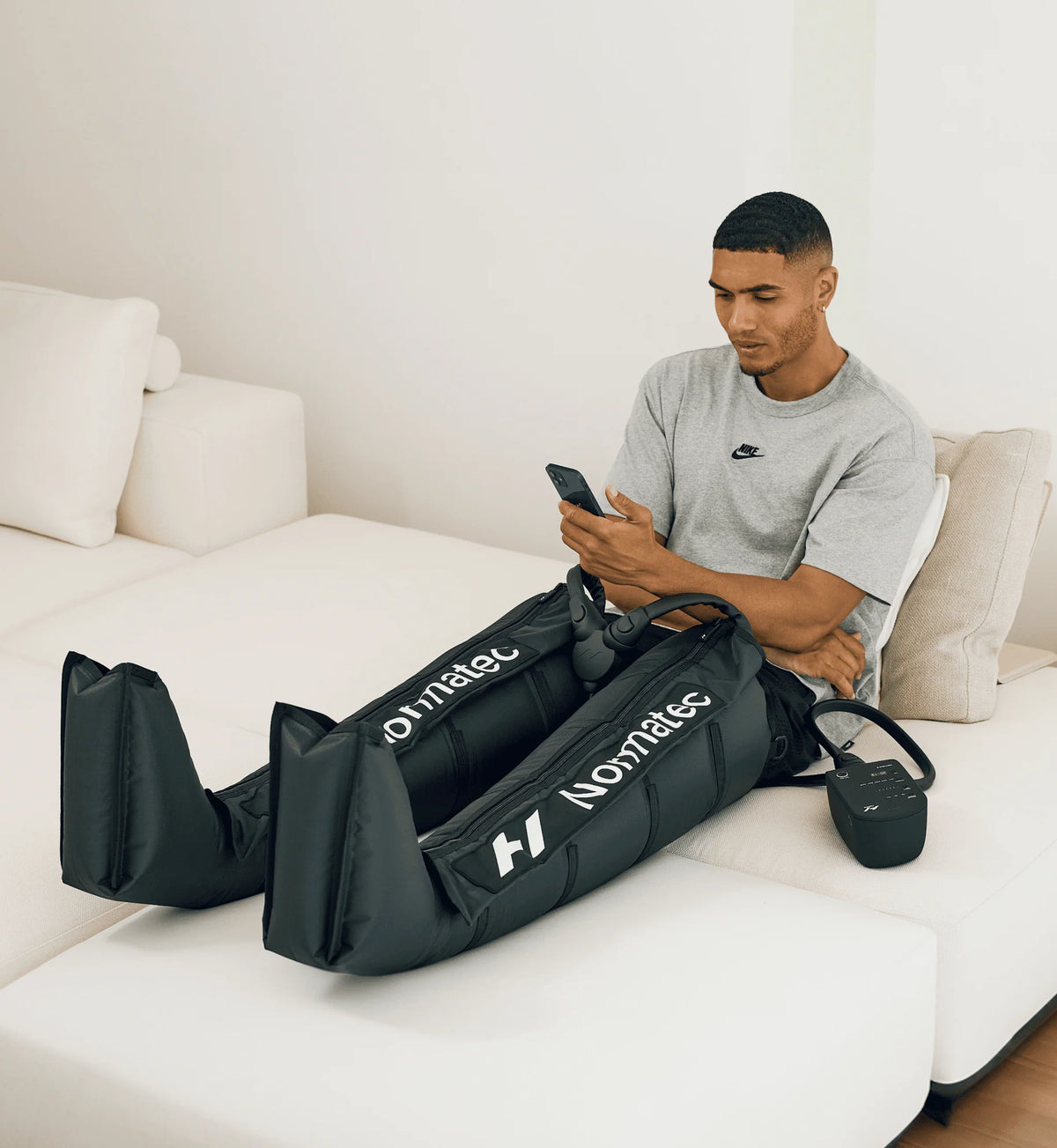 Man using Hyperice Normatec 3 leg attachments for recovery
