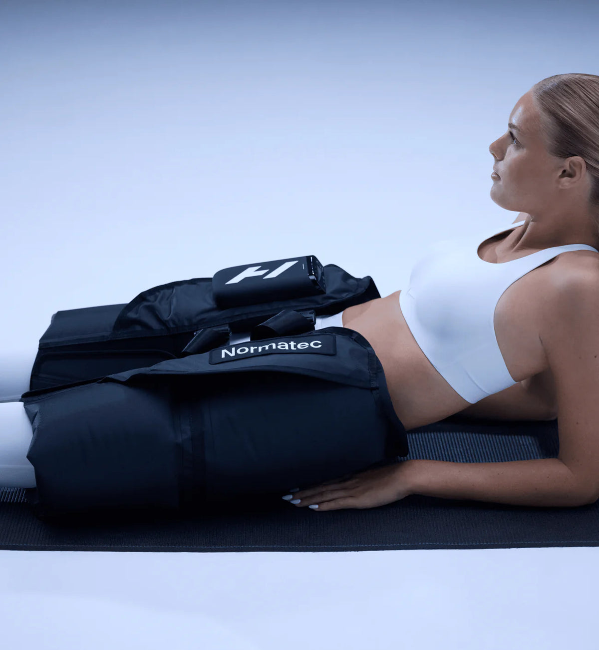 Woman using a Normatec compression device