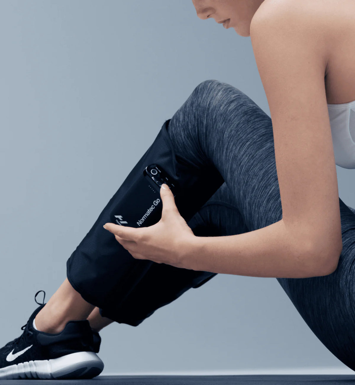 Person using Hyperice Normatec Go calf compression system