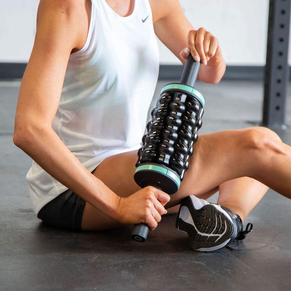 Person using a Chirp RPM™ Rolling Powered Massager on their leg in a gym setting