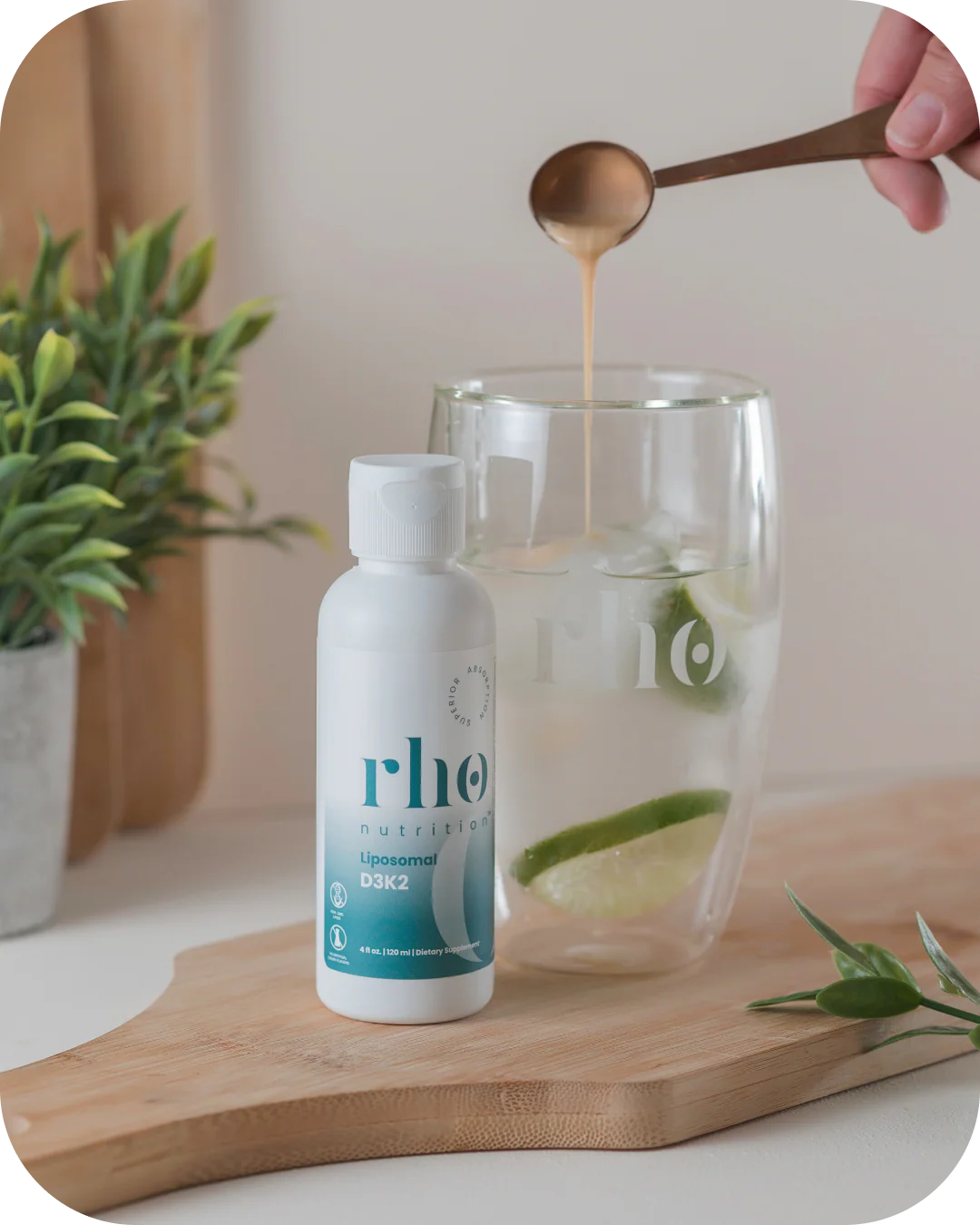 Mixing Rho Nutrition Liposomal D3K2 into water with measuring spoon