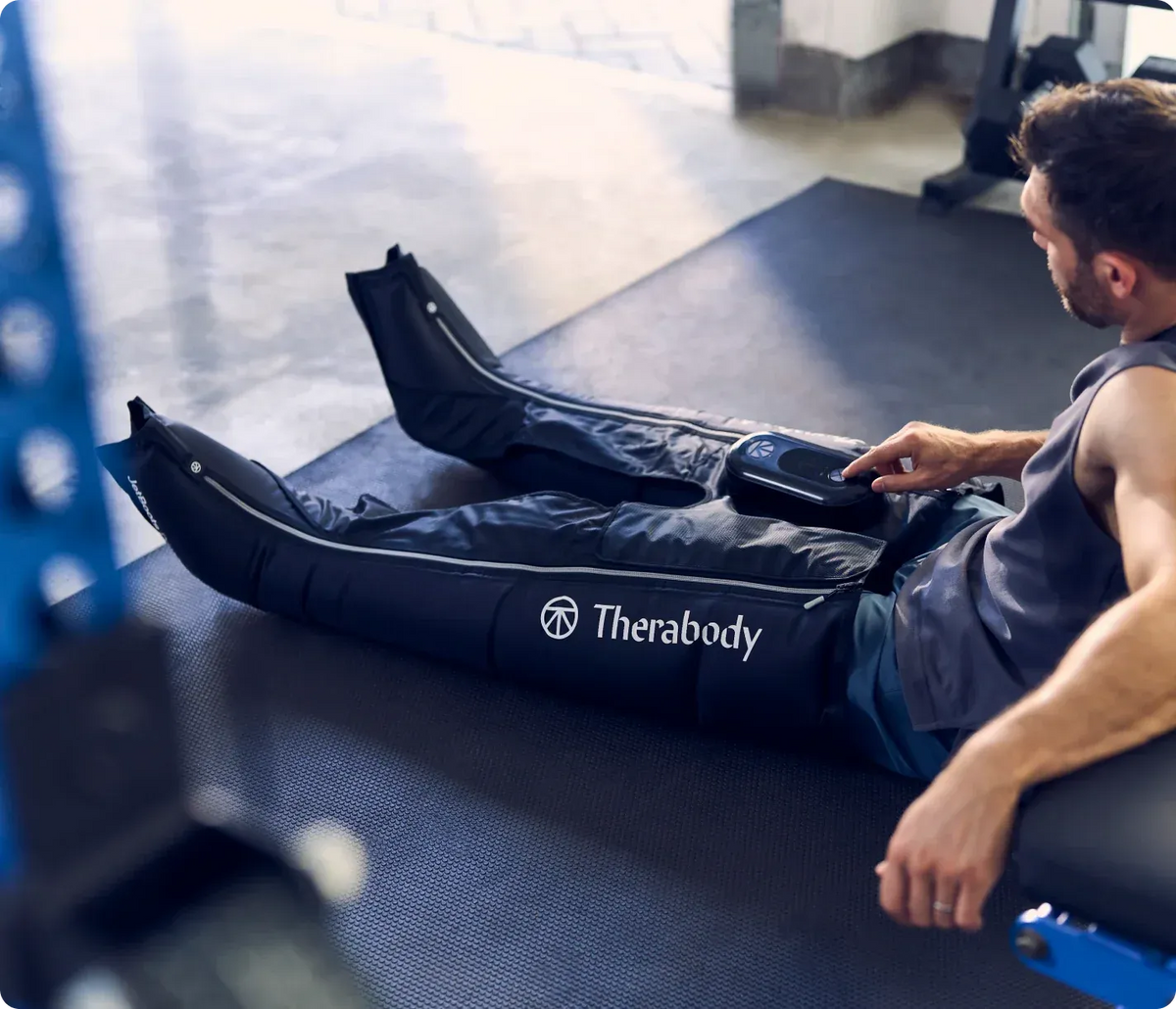 Person using a Therabody JetBoots Prime in a gym setting
