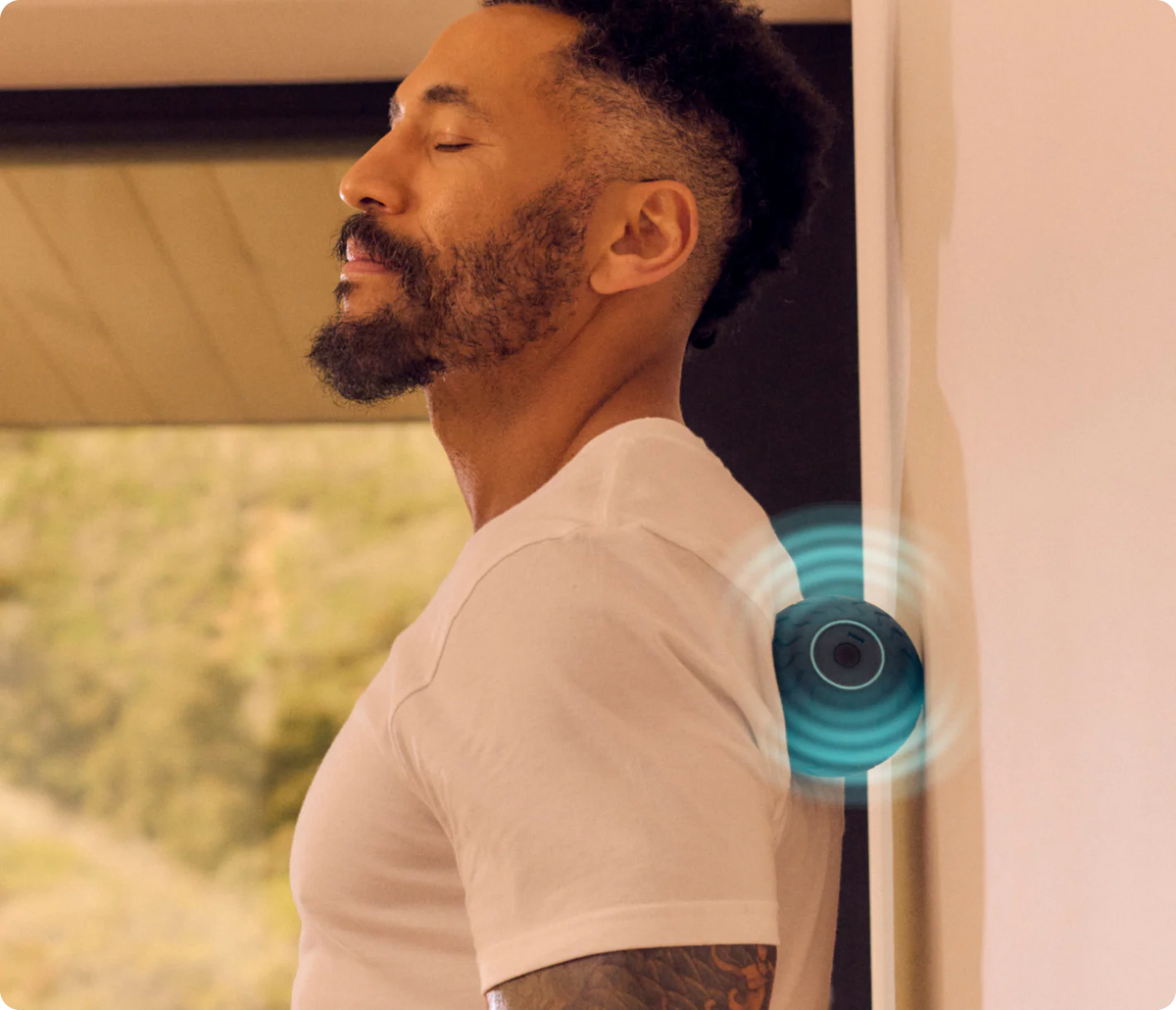 Man using Therabody WaveSolo vibrating ball roller for neck and shoulder muscle relief