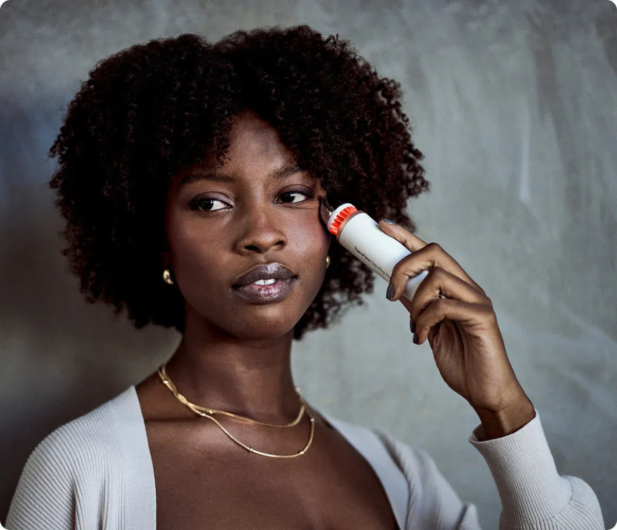 Model using TheraFace Depuff device for targeted under-eye depuffing and skincare treatment