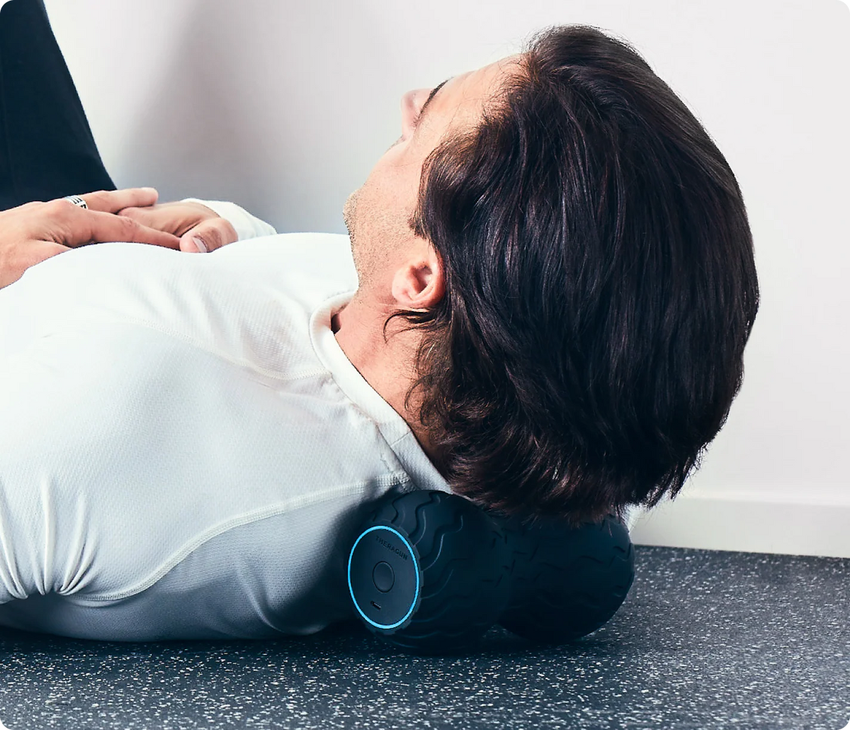 Person using Therabody WaveDuo vibrating muscle roller on the back
