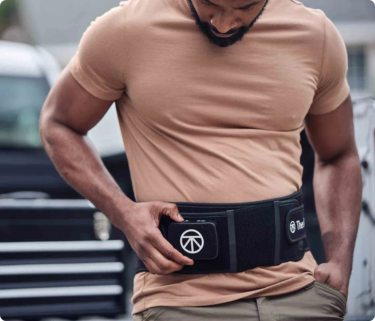 Man wearing ThermBack LED 4-in-1 Back Wrap during red light therapy for back recovery