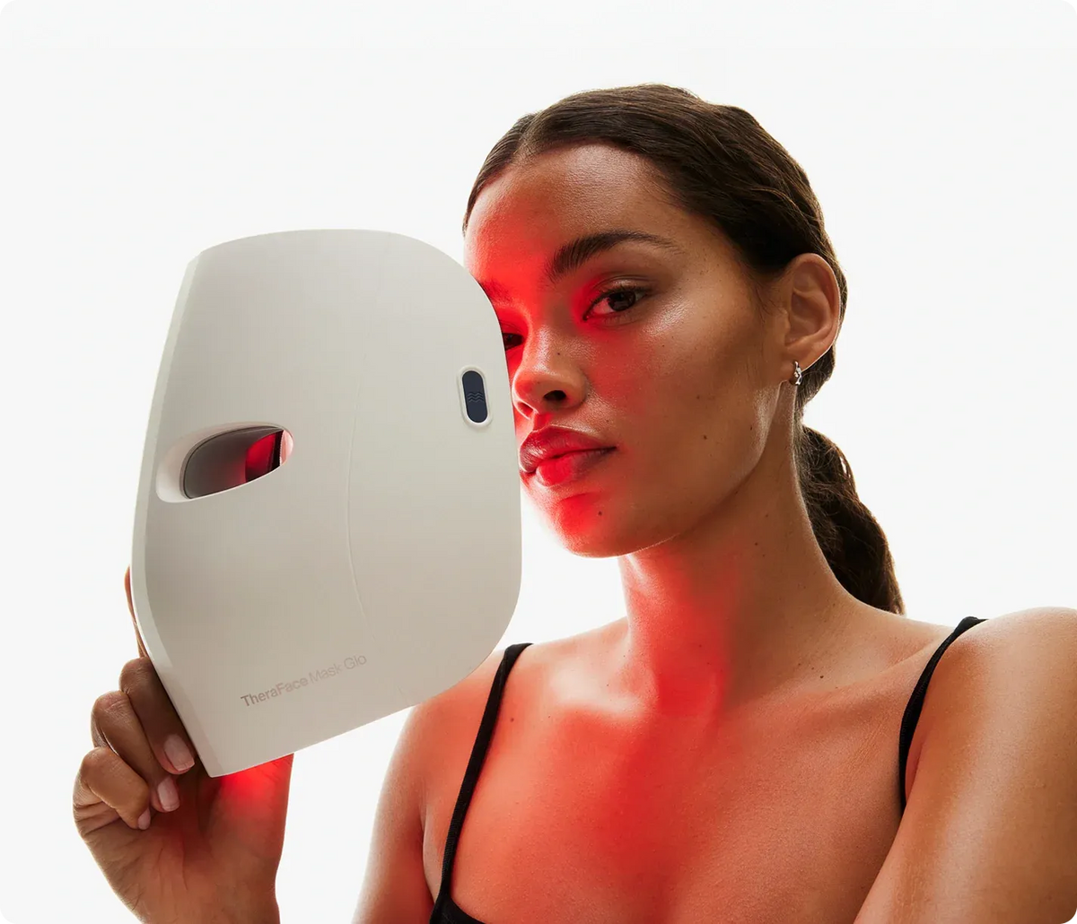Woman using an LED light therapy face mask for red light facial treatment and skin care