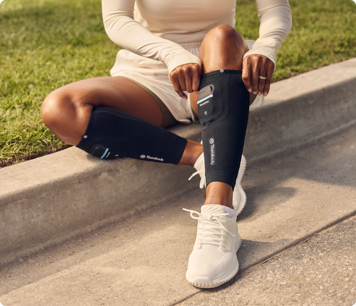 Athlete using Therabody RecoveryPulse Calf compression sleeve after exercise