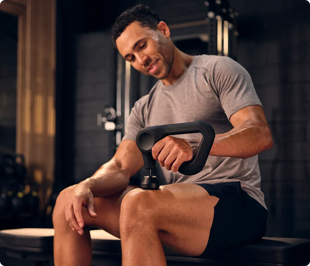 Men using Therabody Theragun massage gun for leg muscle recovery