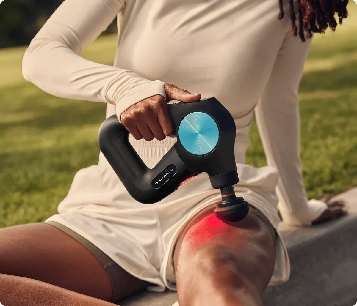 Person using Therabody Theragun Pro Plus on leg muscles