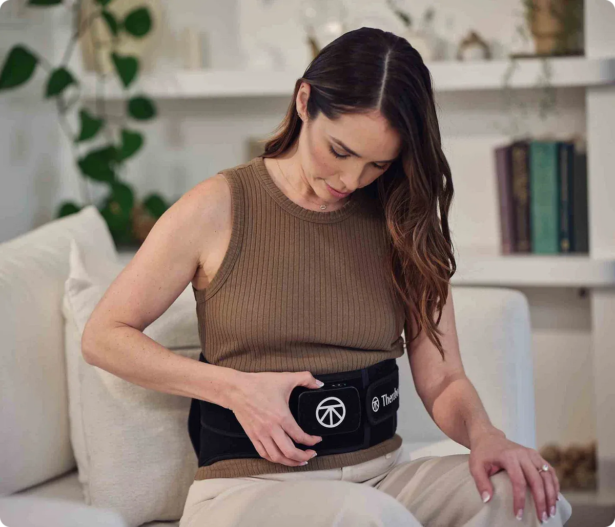 Woman wearing ThermBack LED 4-in-1 Back Wrap while seated for at-home back therapy