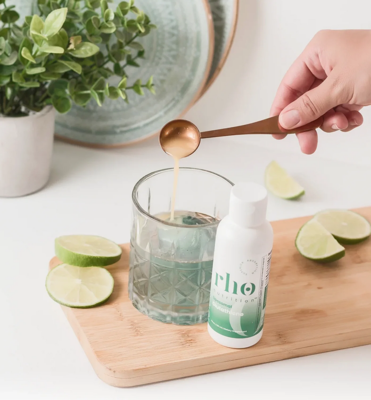 Mixing Rho Nutrition Liposomal Glutathione into water with a measuring spoon