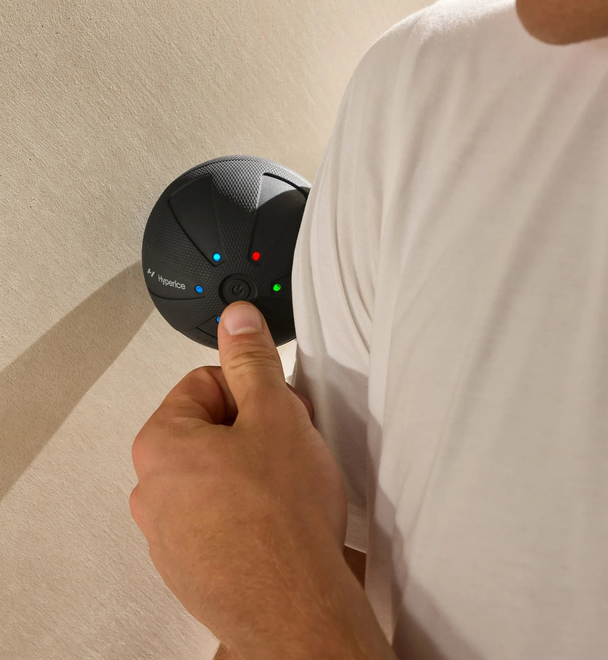 Person holding a Hyperice Hypersphere Go vibrating massage ball against a background