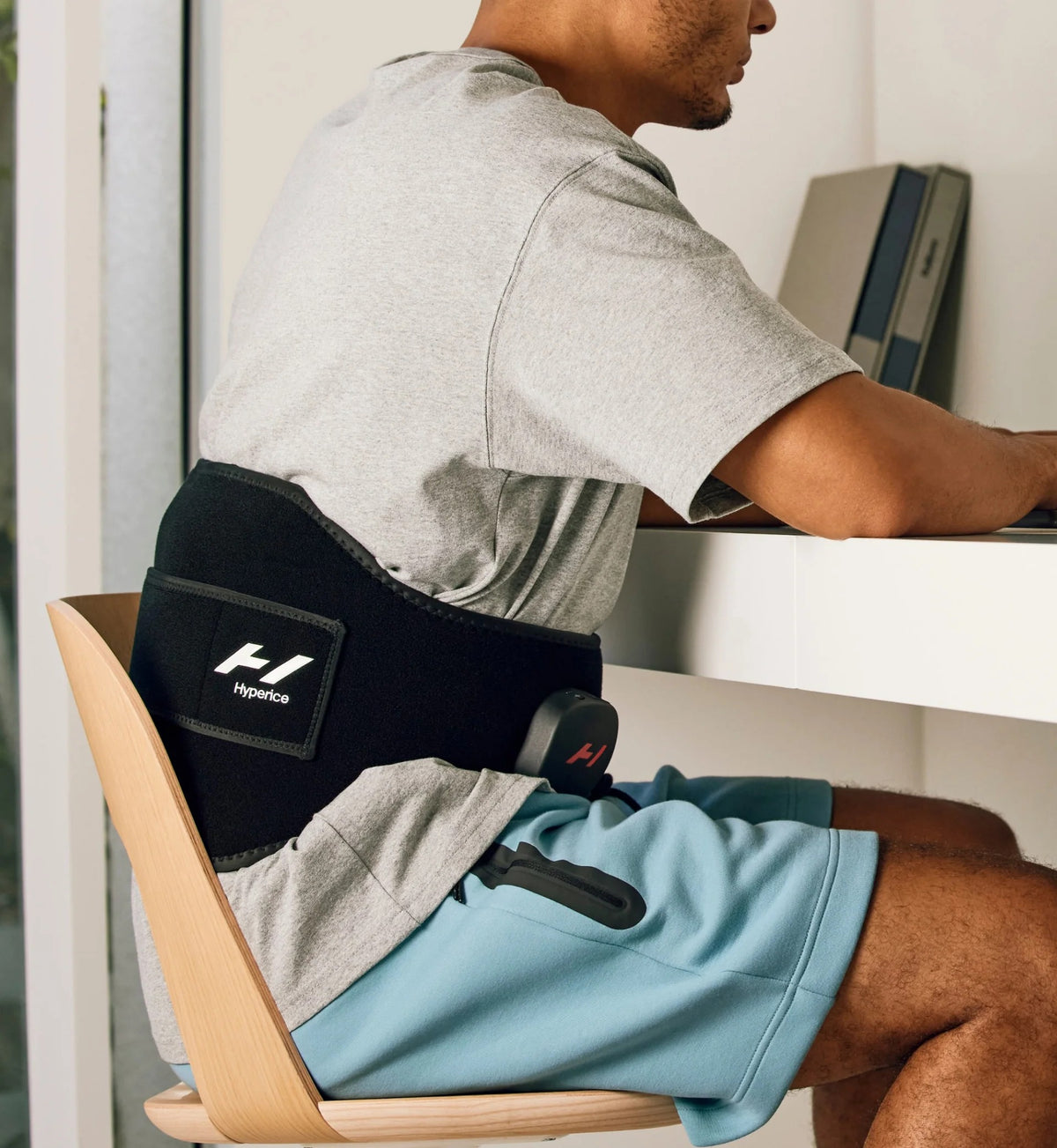 Person wearing Hyperice Venom 2 Back Heated Massage Wrap while seated