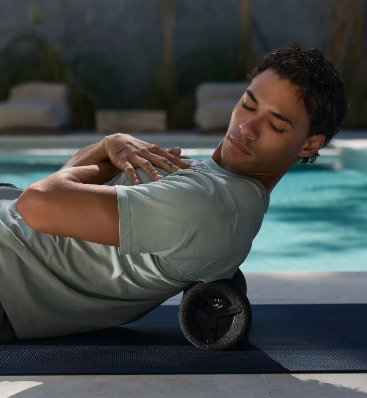 Man using Hyperice Vyper 3 vibrating foam roller for recovery