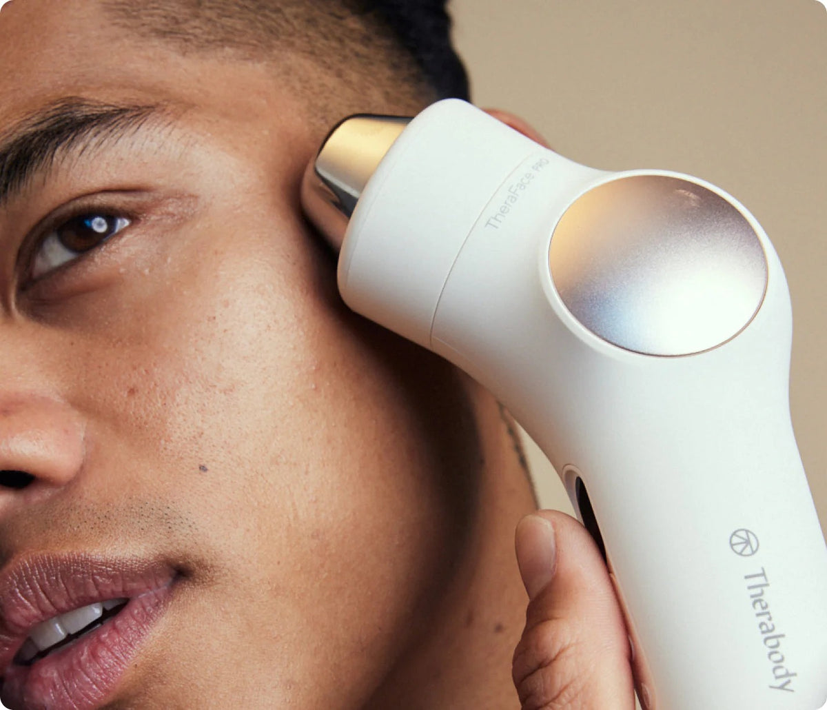 Person using Therabody TheraFace PRO facial massager around the cheek and eye area