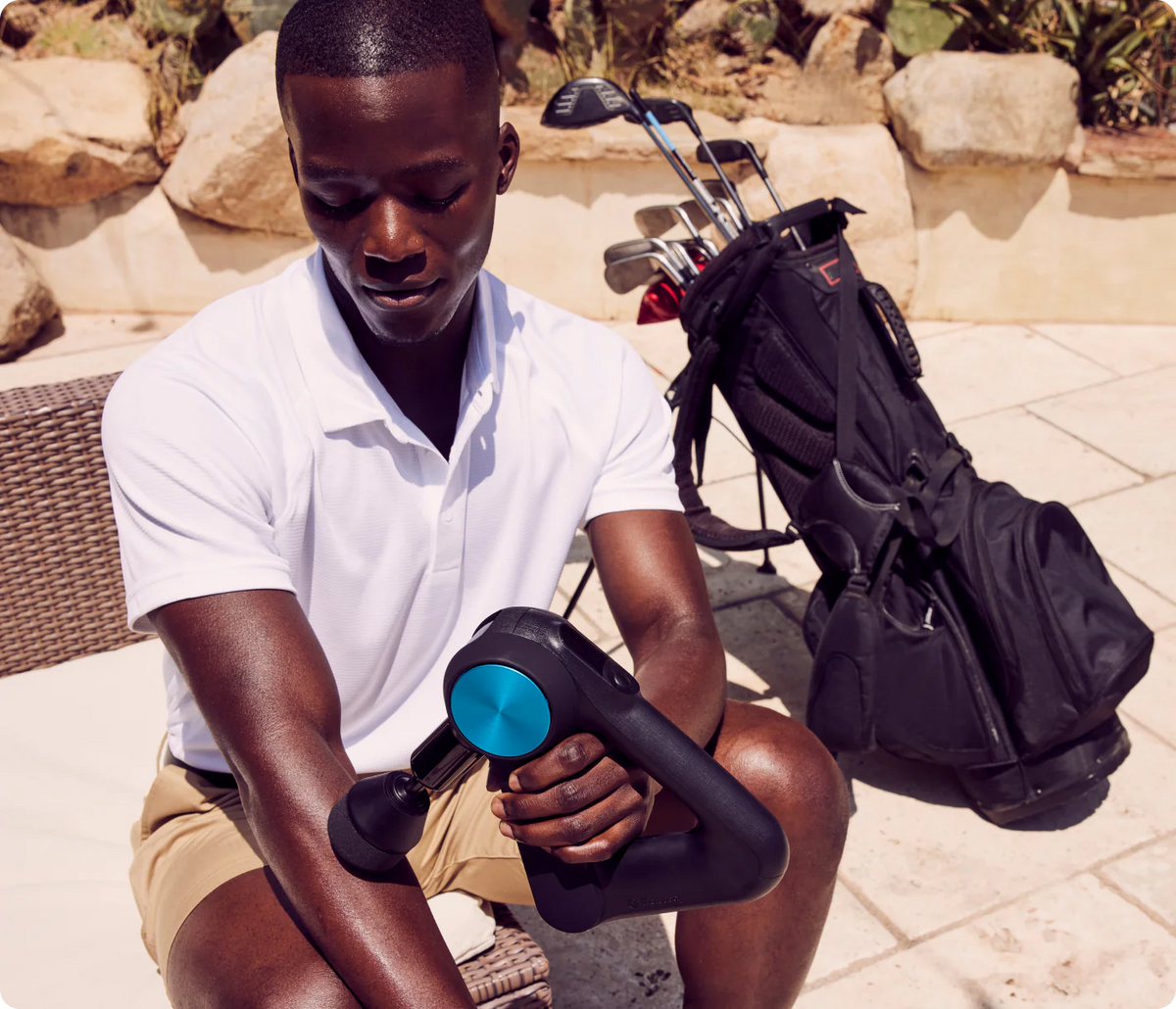Man using Therabody Theragun PRO 5th Gen massage gun during outdoor recovery