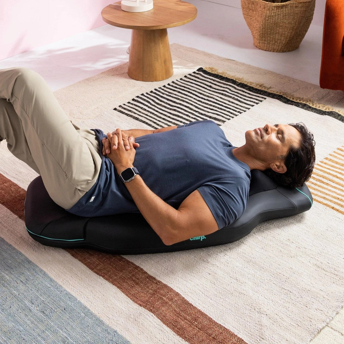 Person relaxing on the Chirp Contour Massage Table for at-home decompression and muscle recovery