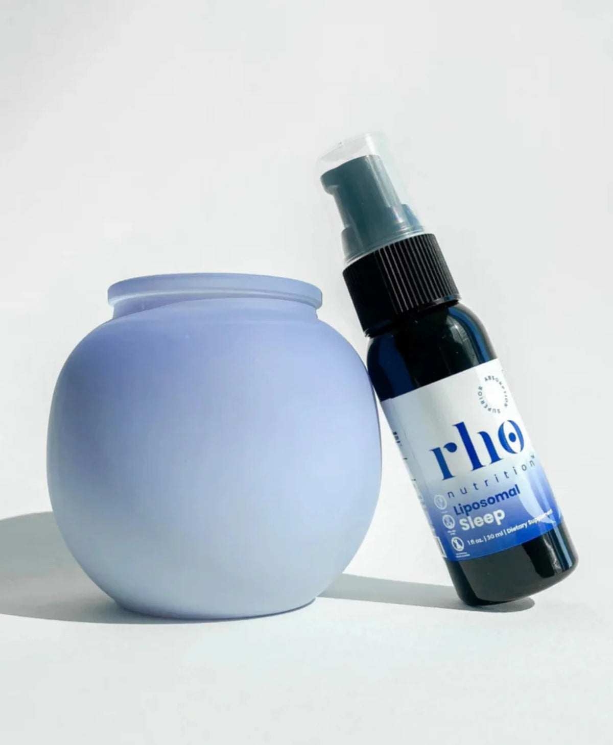 Rho Nutrition Liposomal Sleep Formula spray bottle beside bedside diffuser