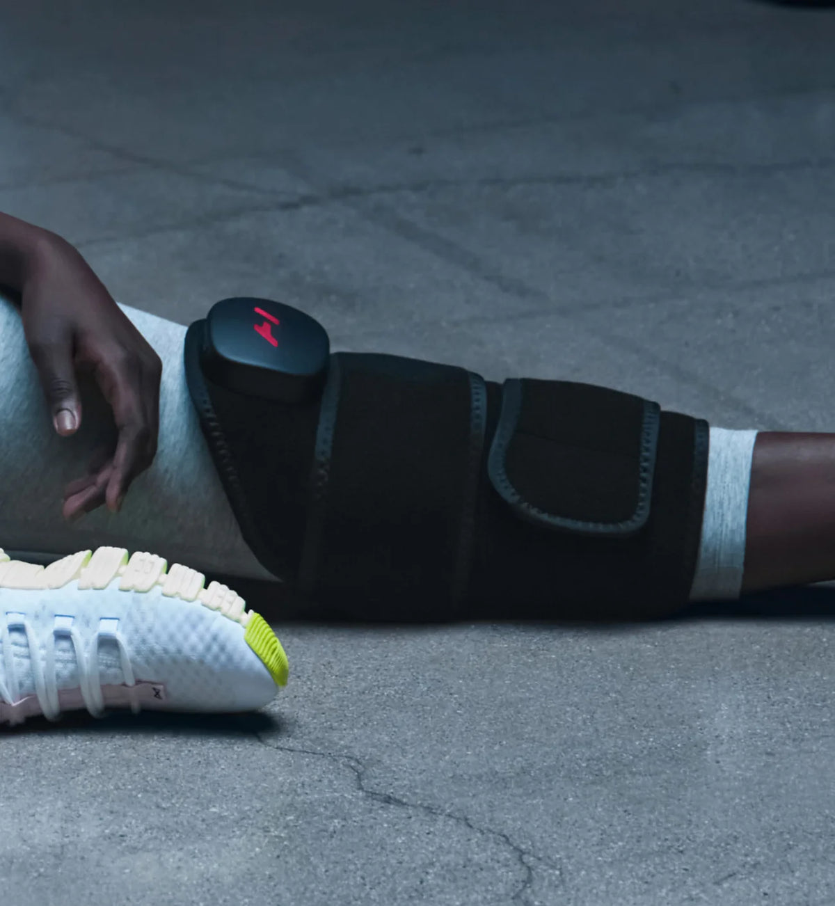 Person using a Hyperice Venom 2 Leg recovery wrap with adjustable strap on their leg 
