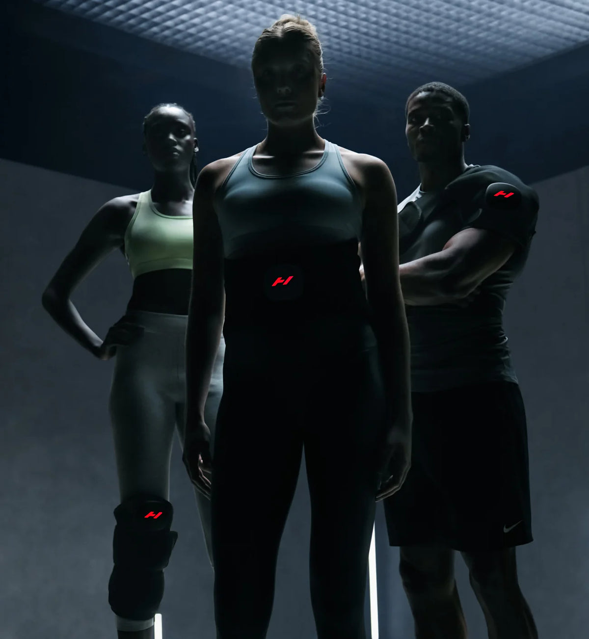 Three athletes in dark athletic wear with Hyperice Venom 2 Leg wrap